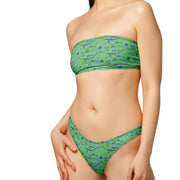 Woman wearing a blue fish patterned bikini with a Green background